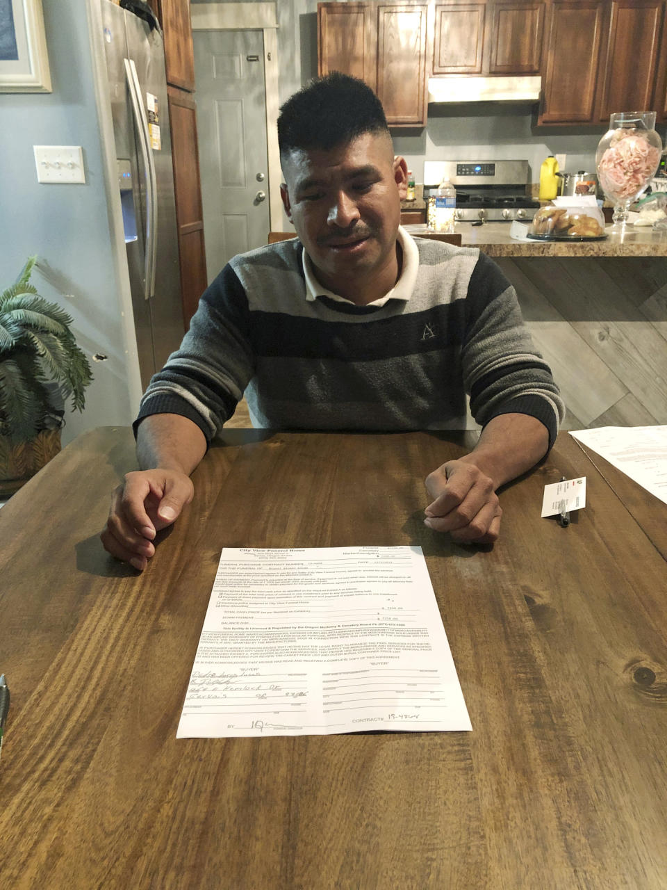 In this Dec. 6, 2019 photo, Pedro Lucas, who is originally from Guatemala, poses for a photo in his home in Gervais, Ore., with a receipt from a funeral home for the costs of a casket and transporting the remains of one of his cousins back to Guatemala after he was killed in a crash Nov. 29, 2019, in Salem, Ore., while being driven home after work on a Christmas tree farm. On Wednesday, Dec. 11, 2019, the U.S. House passed a bill that would loosen restrictions on hiring foreign agricultural workers and create a path to citizenship for more than 1 million farm workers estimated to be in the country illegally. The bill's fate in the Senate is unclear, and the White House hasn't said if President Donald Trump would sign it. But the 260-165 vote was a rare stroke of bipartisanship on immigration. (AP Photo/Andrew Selsky)