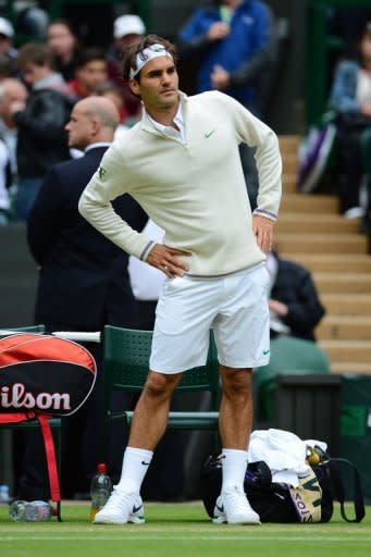 Switzerland's Roger Federer keeps warm during a delay in his fourth round men's singles match against Belgium's Xavier Malisse on day seven of the 2012 Wimbledon Championships at the All England Tennis Club in Wimbledon, southwest London. Federer won 7-6 (7/1), 6-1, 4-6, 6-3