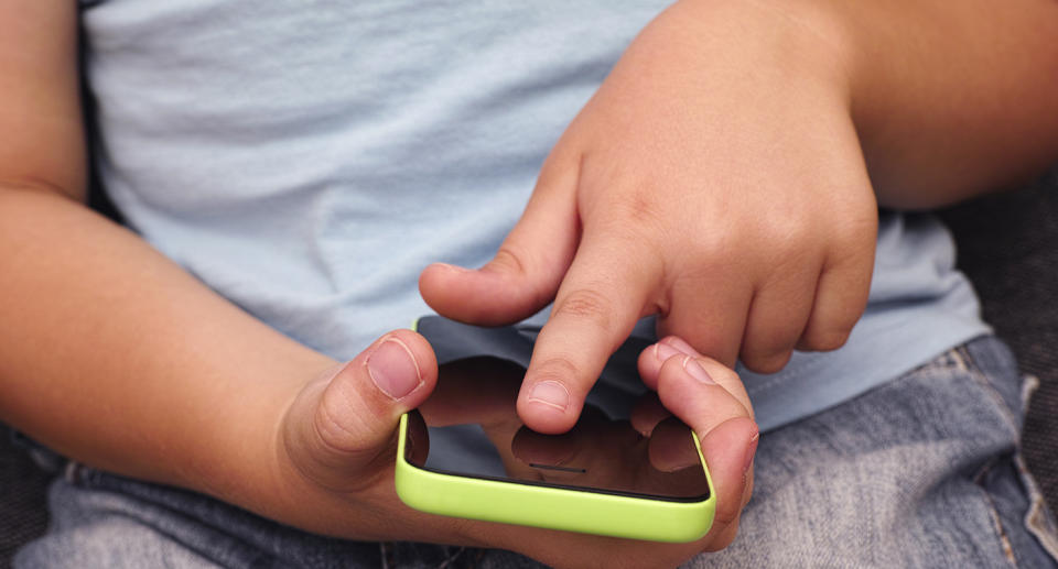 A file picture shows a toddler playing with a smartphone, as a two-year-old girl suffered permanent eye damage from excessive use of electronic devices.