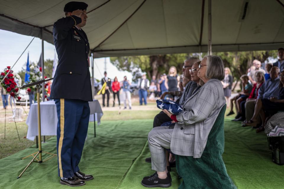Jackie James, niece of Sgt. Turner Yearwood Johnston, is given a folded American flag at his funeral on Oct. 21 in Belton. The Texan was killed in action in Romania in 1943, but his remains were only recently identified, and he was buried in North Belton Cemetery last month.