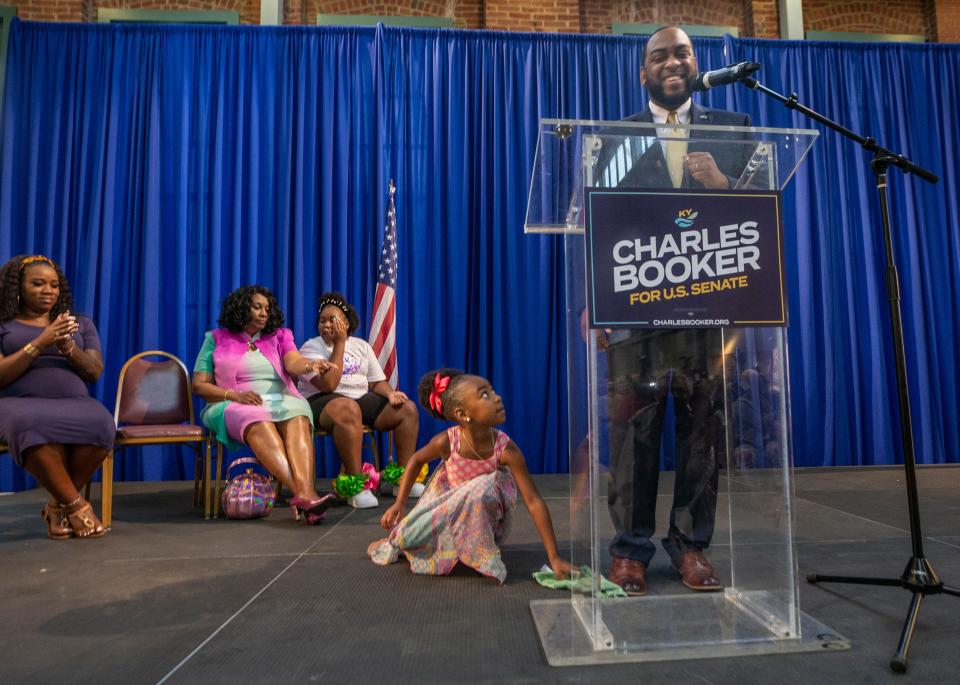 Prestyn Booker, 4, picks up a towel her father Charles Booker dropped as he was announcing he will run for Rand Paul's U.S. Senate seat. Background, left to right, wife, Tanesha Booker, mother, Earletta Hearn and daughter Kaylin. July 1, 2021