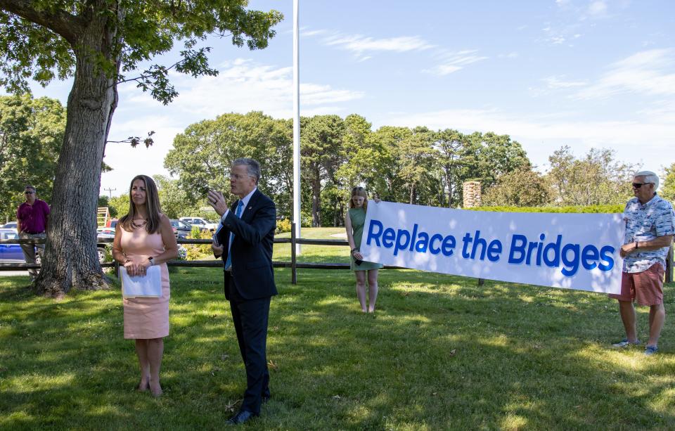 At the Veterans Memorial Park in Hyannis, Chris Doughty introduces himself while Ally Webster, a campaign staff member, left. Daniel Webster, campaign senior advisor, right, holds the “Replace The Bridge” banner.