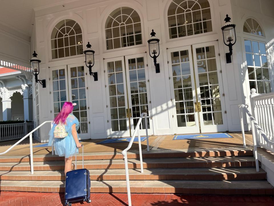 jenna dragging her rolling suitcase up the steps at the grand floridian to luggage services