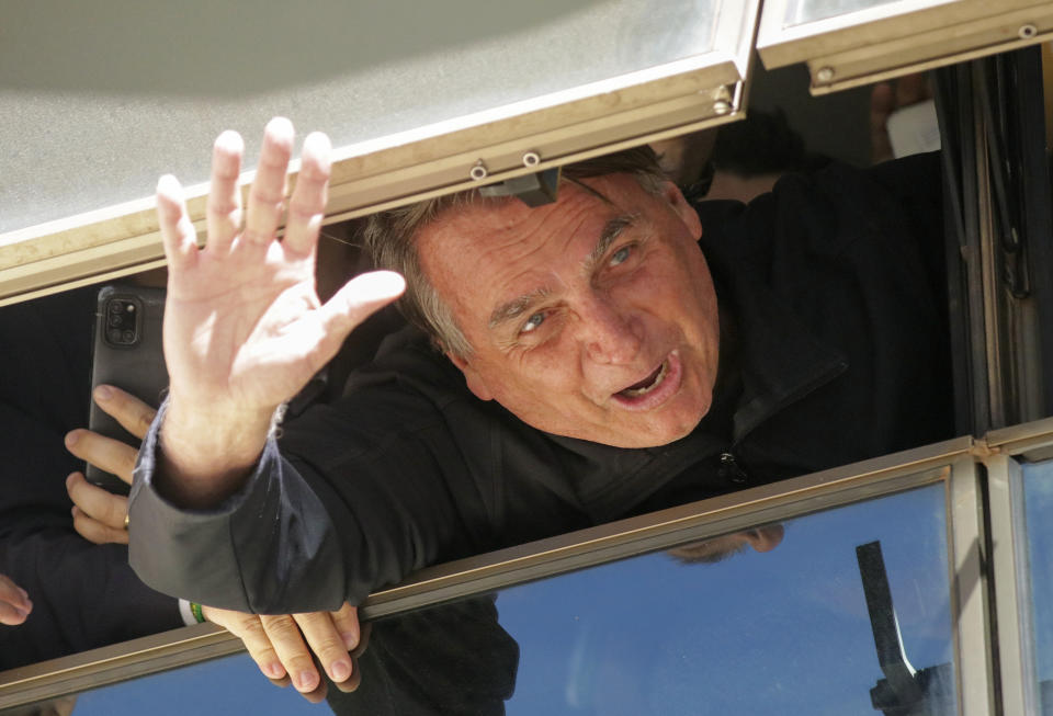 Brazil's former President Jair Bolsonaro waves to supporters at the Liberal Party's headquarters in Brasilia, Brazil, Thursday, March 30, 2023. Bolsonaro arrived back in Brazil on Thursday after a three-month stay in Florida, seeking a new role on the political scene. (AP Photo/Gustavo Moreno)