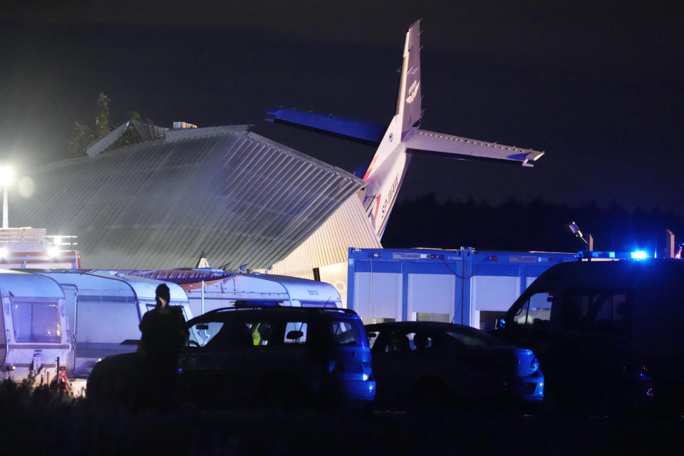 The tail of a Cessna 208 plane sticks out of a hangar after it crashed there in bad weather killing several people and injuring others, at a sky-diving centre in Chrcynno, central Poland, on Monday, July 17, 2023. (AP Photo/Czarek Sokolowski)
