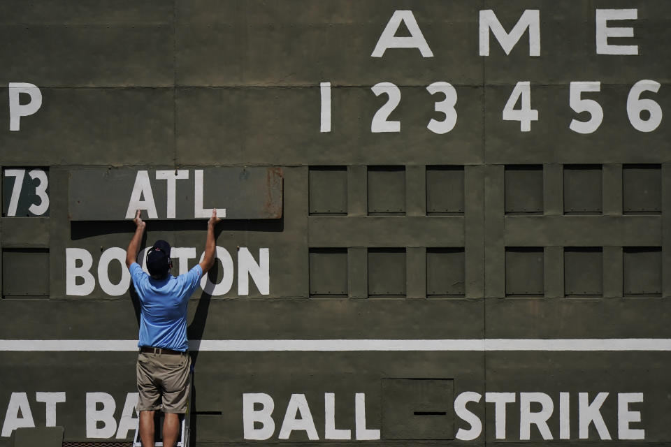 An attendance places the Atlanta Braves sign on the Green Monster score board before a spring training baseball game against the Boston Red Sox on Monday, March 1, 2021, in Fort Myers, Fla. (AP Photo/Brynn Anderson)