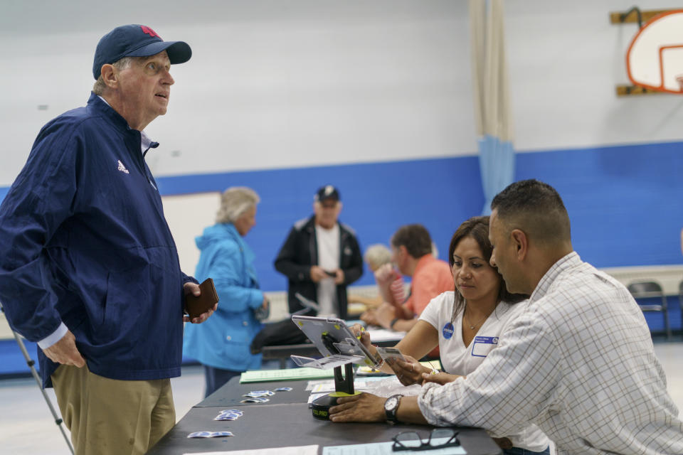 Rhode Island Gov. Dan McKee checks in at a polling site to cast his vote in the state's primary election at the Community School, Tuesday, Sept. 13, 2022, in Cumberland, R.I. (AP Photo/David Goldman)