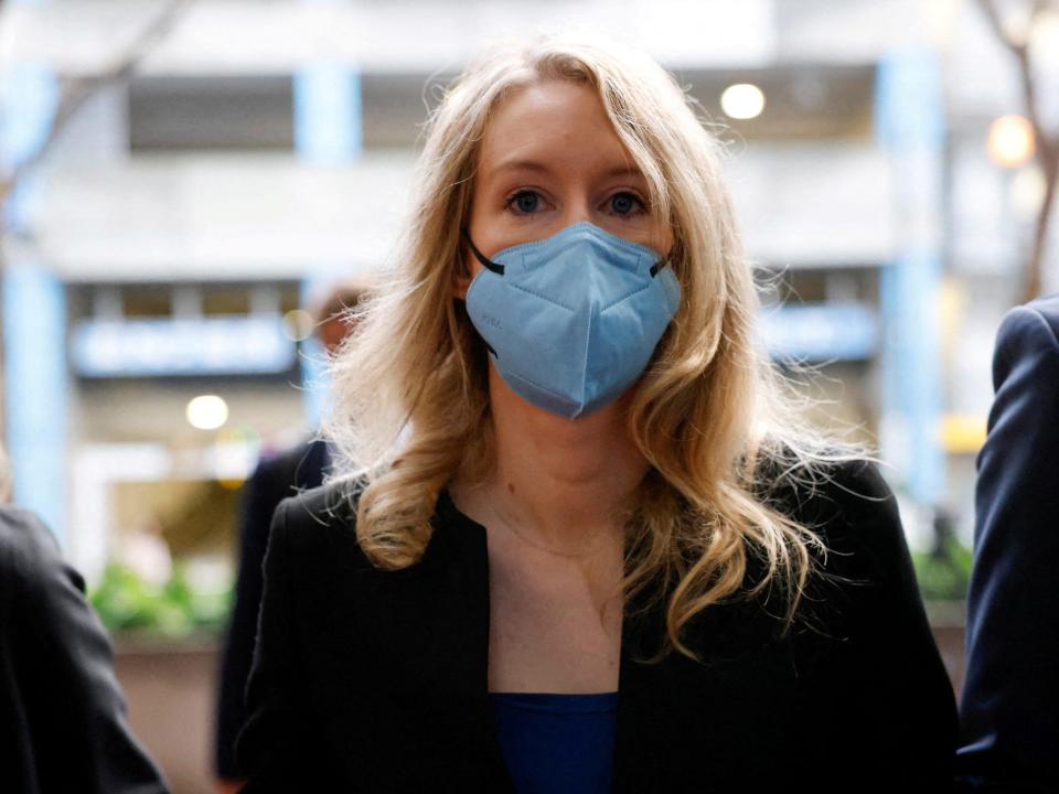 Theranos founder Elizabeth Holmes wears a blue mask walking to federal court