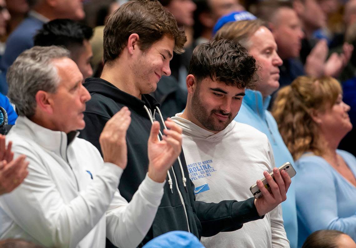 North Carolina quarterback Drake Maye and former quarterback Sam Howell sit behind the North Carolina bench during the Tar Heels’ game against Duke on Saturday, February 4, 2023 at Cameron Indoor Stadium in Durham, N.C. Robert Willett/rwillett@newsobserver.com