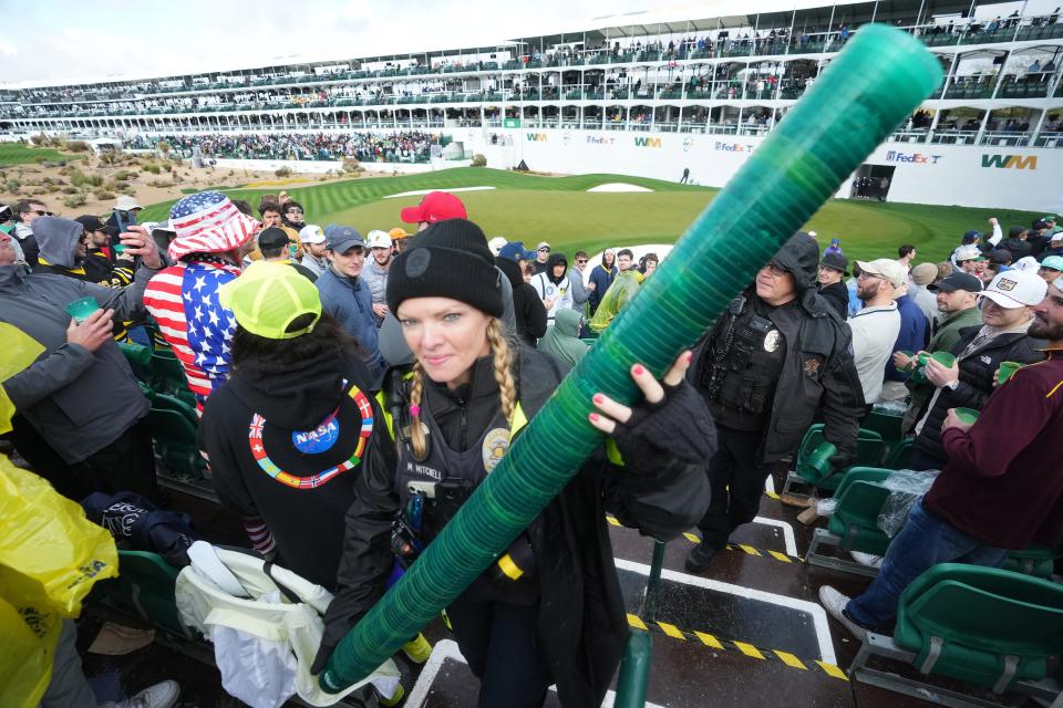 A Scottsdale police officer confiscates a 'beer snake' from fans on the 16th hole during the 2024 Phoenix Open at TPC Scottsdale on Feb. 10, 2024.