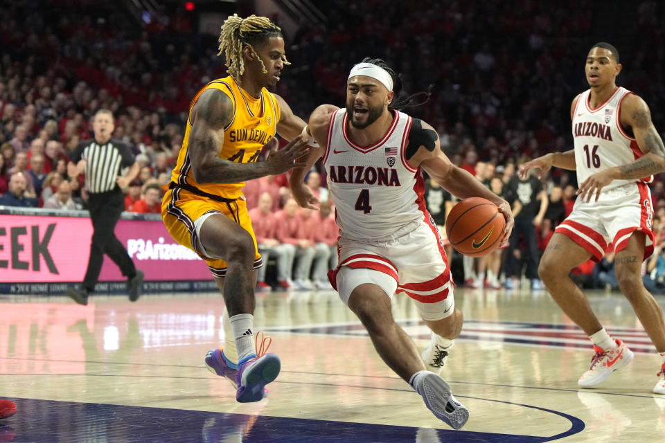 Arizona guard Kylan Boswell (4) drives past Arizona State guard Adam Miller, left, during the first half of an NCAA college basketball game, Saturday, Feb. 17, 2024, in Tucson, Ariz. (AP Photo/Rick Scuteri)