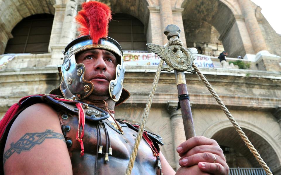 Rome's latter-day legionaries and centurions make a living by dressing up and charging tourists to take a photograph with them. - AFP