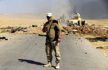 An Iraqi soldier carries his weapon during the war between Iraqi army and Shi'ite Popular Mobilization Forces (PMF) against the Islamic State militants in al-Ayadiya, northwest of Tal Afar, Iraq August 28, 2017. REUTERS/Thaier Al-Sudani