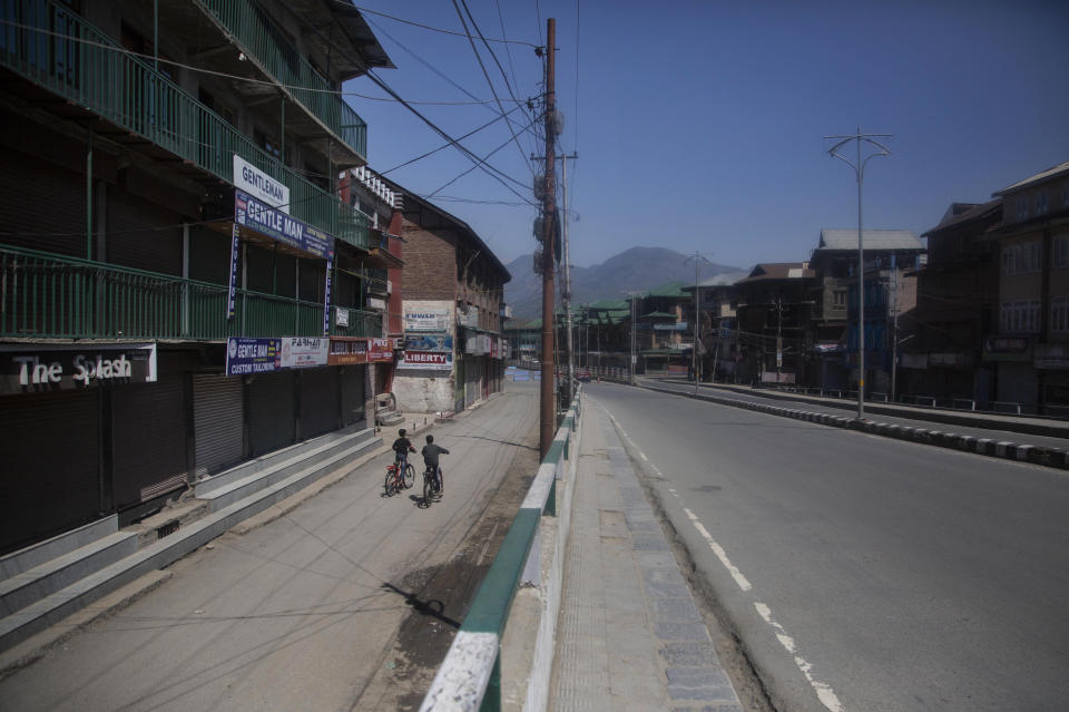 Kashmiri boys ride on their bicycles on a deserted road during lockdown to prevent the spread coronavirus in Srinagar, Indian-controlled Kashmir, Sunday, April 25, 2021. (AP Photo/Mukhtar Khan)