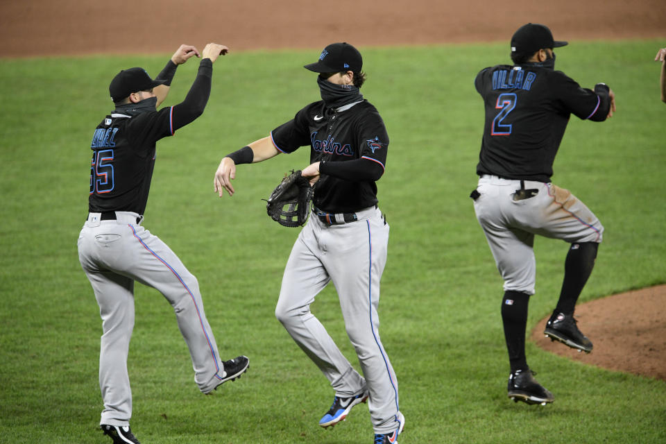 Miami Marlins' Brian Anderson, center, Eddy Alvarez, left, and Jonathan Villar (2) celebrate after a baseball game against the Baltimore Orioles, Thursday, Aug. 6, 2020, in Baltimore. (AP Photo/Nick Wass)