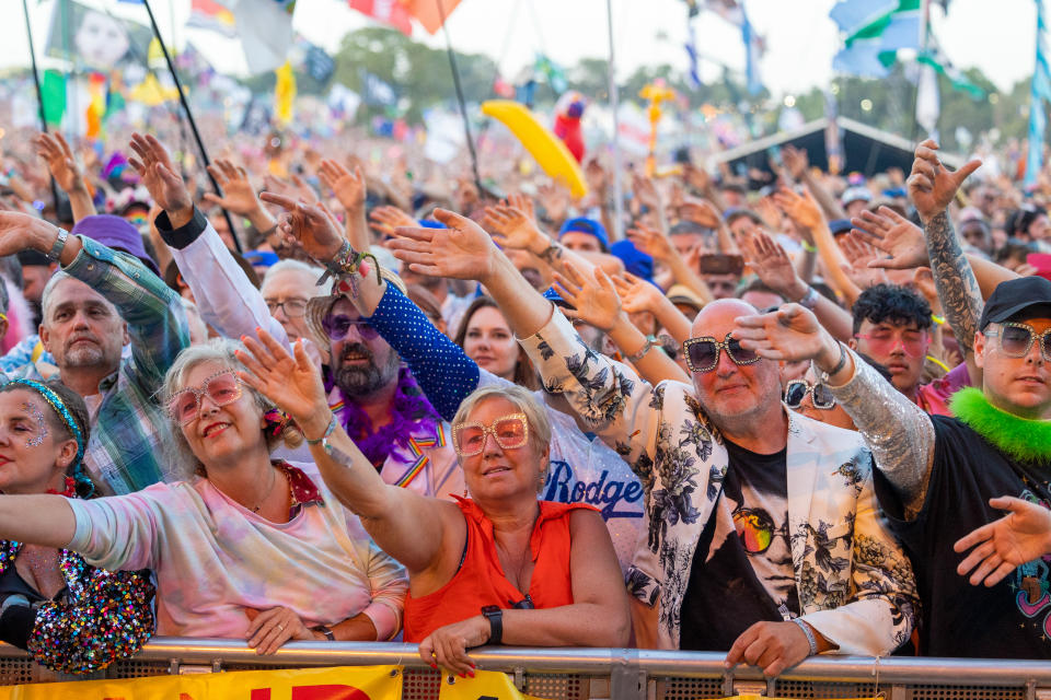 The crowd in front of the main Pyramid Stage at Glastonbury dance and cheer as they watch Elton John perform