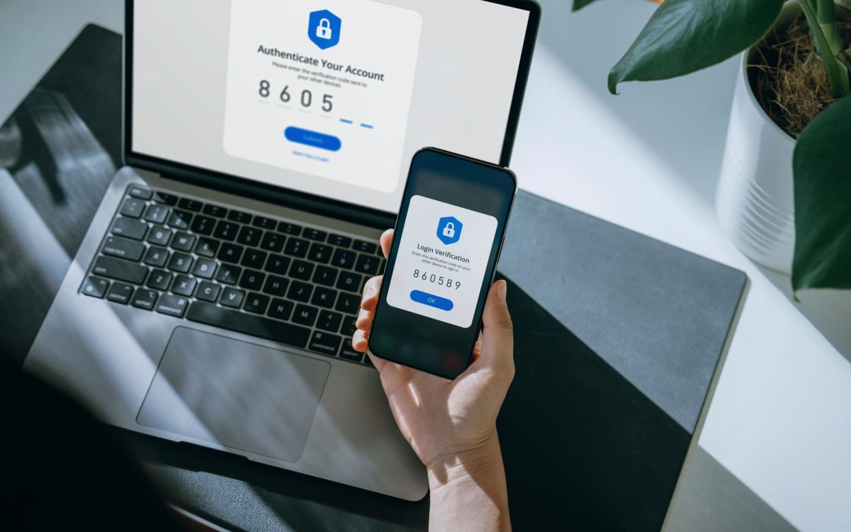 person using phone text code to login to website - Yiu Yu Hoi/Getty Images