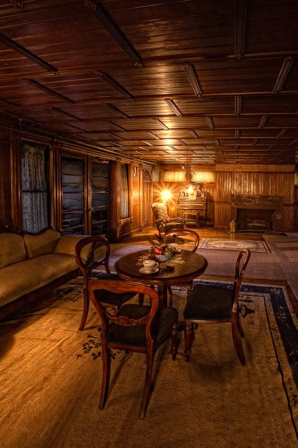 a table, couch, and fireplace in the ventian dining room at the winchester mansion