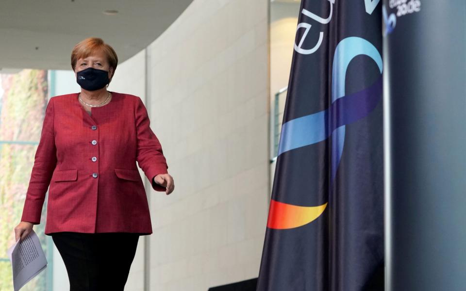 German Chancellor Angela Merkel arrives for a statement after a conference call with the mayors of the eleven biggest German cities - Shutterstock