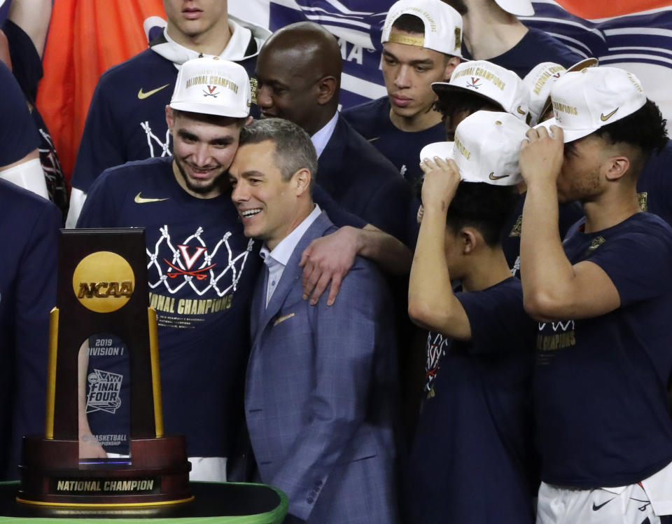 FILE - Virginia head coach Tony Bennett, center, celebrates with guard Ty Jerome, left, after the championship game against Texas Tech in the Final Four NCAA college basketball tournament, Monday, April 8, 2019, in Minneapolis. Virginia won 85-77 in overtime. Virginia fell to UMBC in the first-ever 16-vs-1 upset in 2018. Yet those Cavaliers regrouped to win the national championship the following season. (AP Photo/Matt York, File)