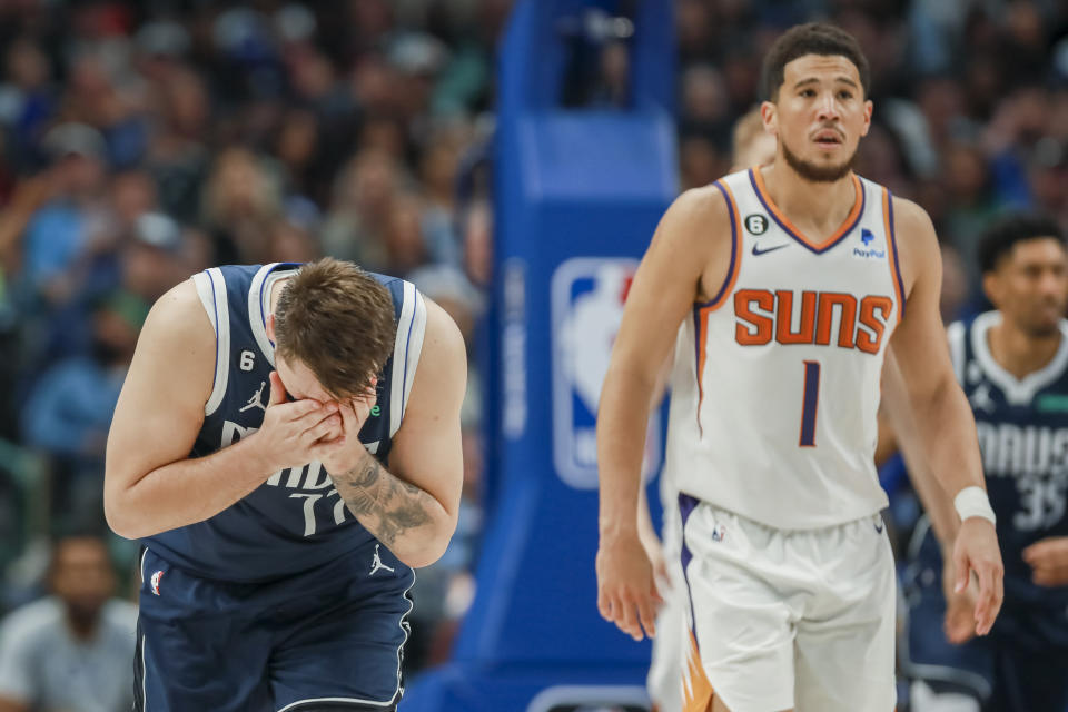 Dallas Mavericks guard Luka Doncic (77) reacts after a missed shot, as Phoenix Suns guard Devin Booker (1) looks on during the second half of an NBA basketball game, Sunday, March 5, 2023, in Dallas. (AP Photo/Gareth Patterson)