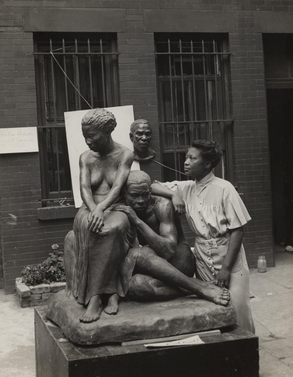 Augusta Savage leans against her sculpture "Realization" in 1938.