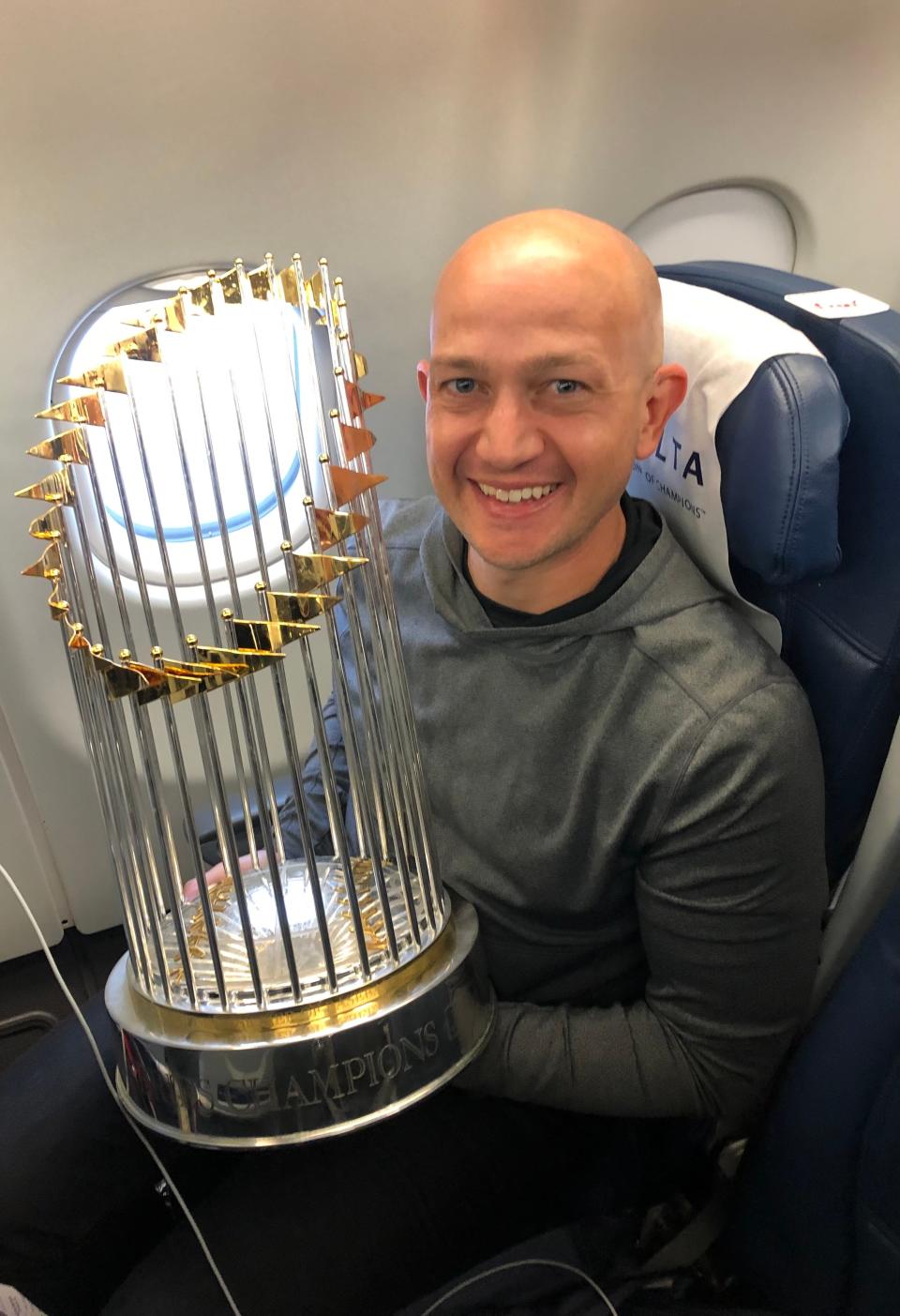 Dr. Lee Kneer holding the Braves’ World Series trophy.