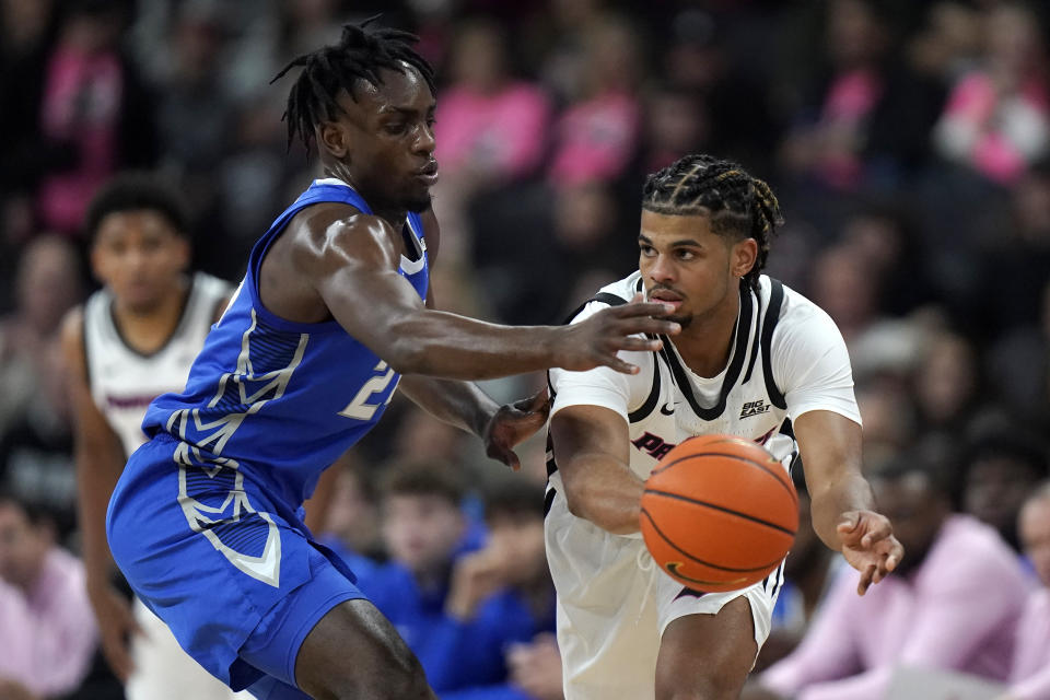 Creighton forward Arthur Kaluma, left, defends as Providence forward Bryce Hopkins, right, passes the ball in the first half of an NCAA basketball game, Tuesday, Feb. 14, 2023, in Providence, R.I. (AP Photo/Steven Senne)