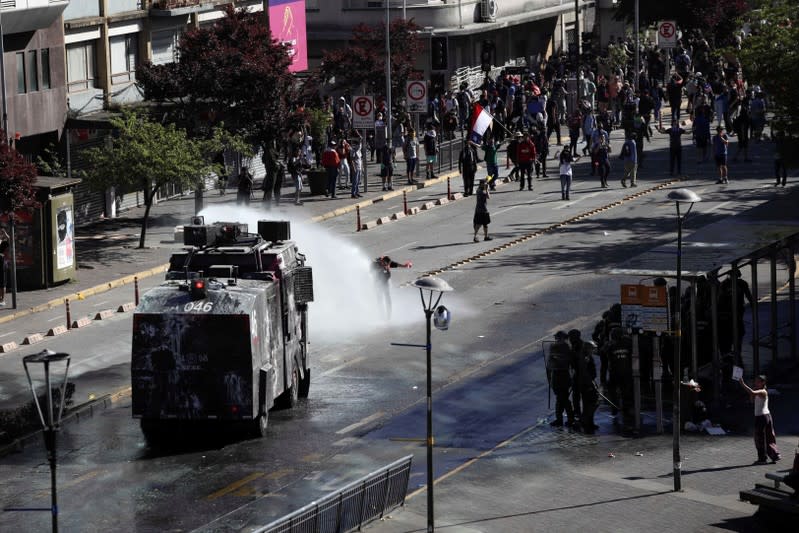 A riot police vehicle releases a jet of water during a protest against Chile's state economic model in Concepcion