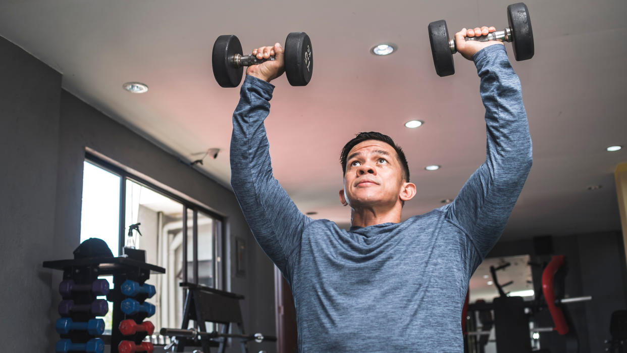  Man performing dumbbell shoulder press 