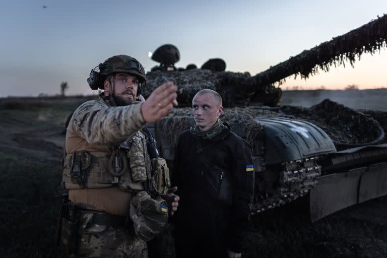 Un soldado al mando de la Brigada 22 de Ucrania da instrucciones frente a un tanque T-72 durante un ejercicio de tiro nocturno.