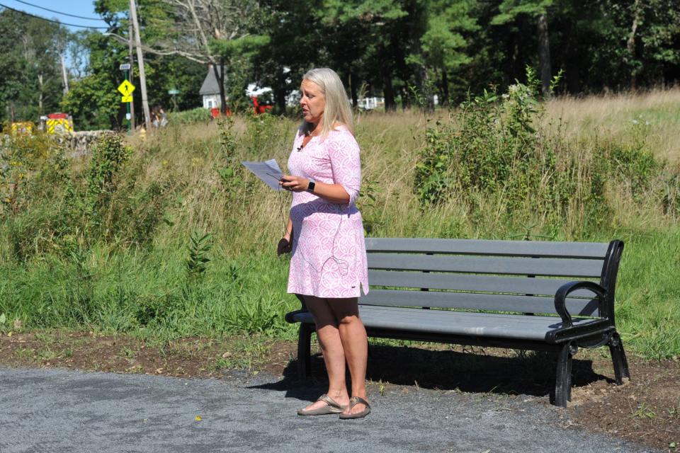 Norwell Beautification Committee member Sarah Baker speaks with emotion about the late Nancy Hemingway, who served as the town's conservation agent for a decade, during the dedication of a garden in her memory.