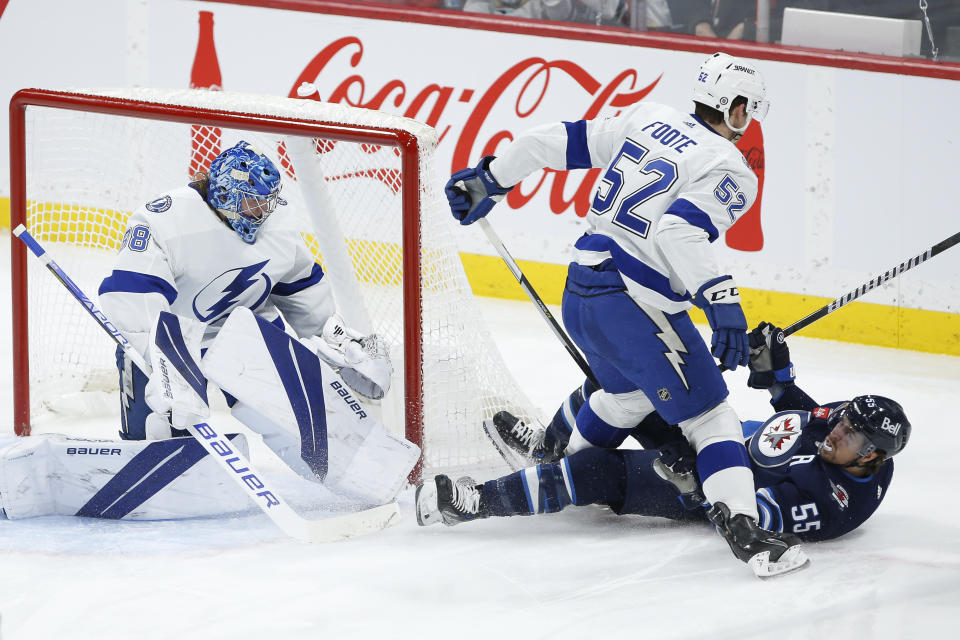 Winnipeg Jets' Mark Scheifele (55) is hauled down by Tampa Bay Lightning's Cal Foote (52) in front of Lightning goaltender Andrei Vasilevskiy (88) during second-period NHL hockey game action in Winnipeg, Manitoba, Friday, Jan. 6, 2023. (John Woods/The Canadian Press via AP)