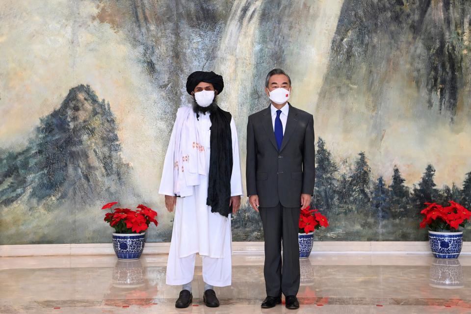 Taliban co-founder Mullah Abdul Ghani Baradar, left, and Chinese Foreign Minister Wang Yi, pose for a photo during their meeting in Tianjin, China (AP)