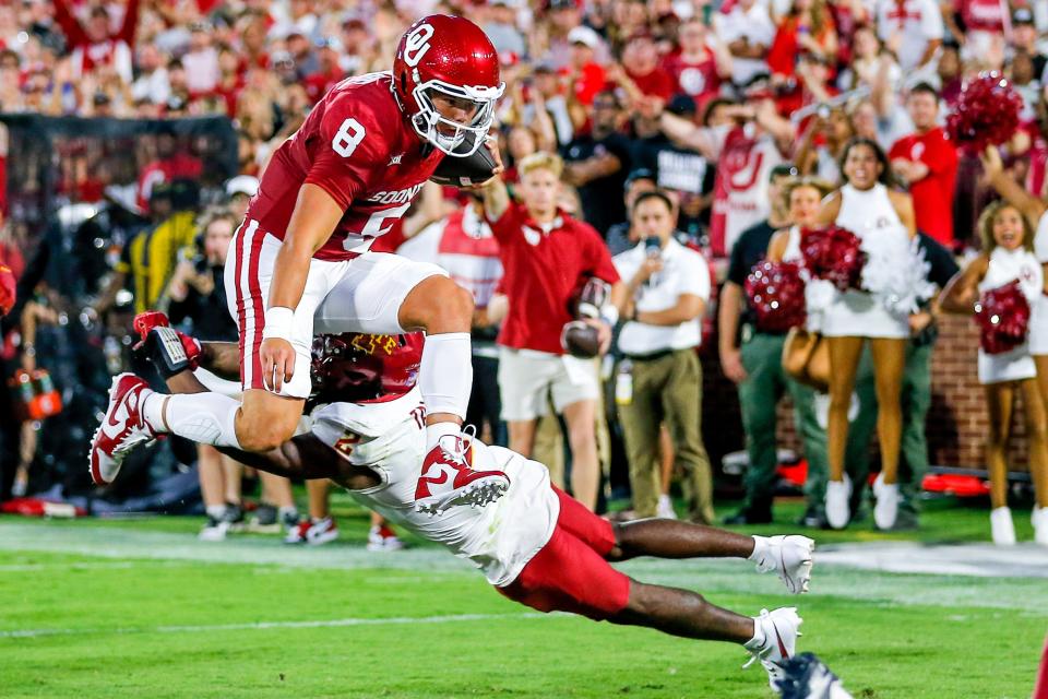 Oklahoma's Dillon Gabriel leaps over Iowa State's T.J. Tampa to score a touchdown in the second quarter of their game at the Gaylord Family Oklahoma Memorial Stadium in Norman, Okla.