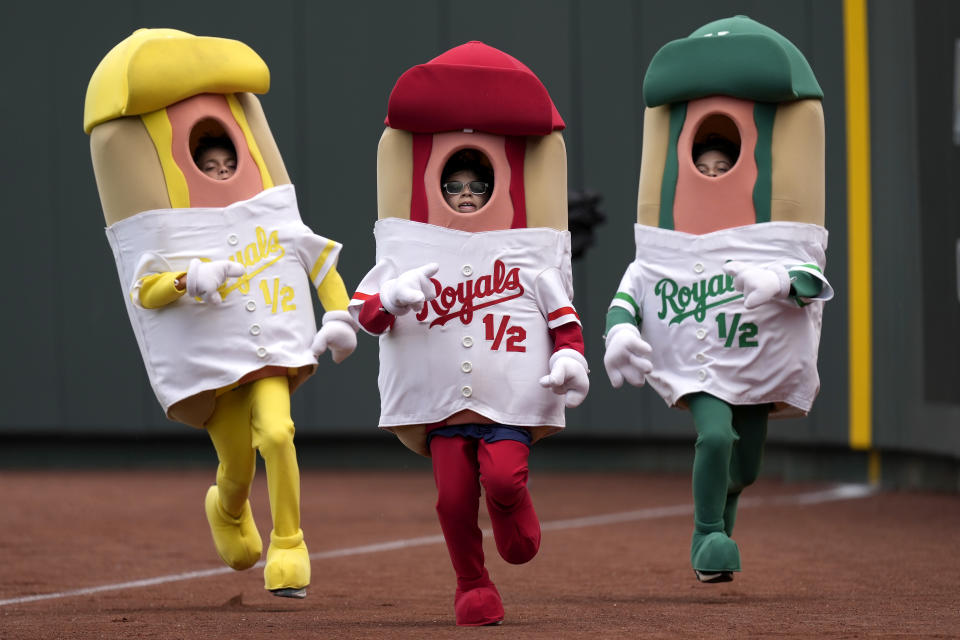 Kids in hot dog costumes compete in the hot dog derby during the fourth inning of a baseball game between the Kansas City Royals and the San Diego Padres Sunday, June 2, 2024, in Kansas City, Mo. (AP Photo/Charlie Riedel)