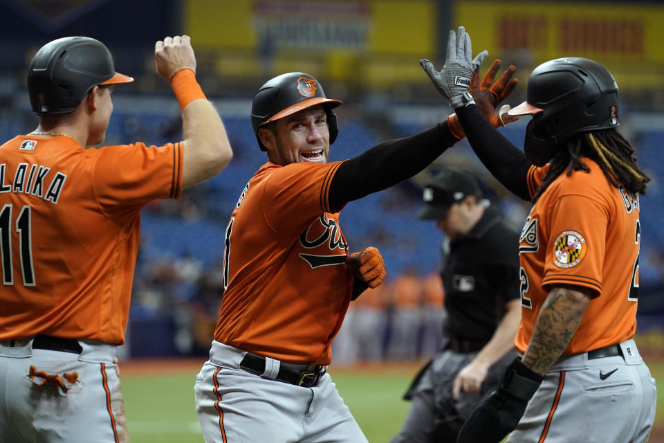 Baltimore Orioles' Austin Wynns, center, celebrates his grand slam off Tampa Bay Rays starting pitcher Rich Hill with Pat Valaika, left, and Freddy Galvis, right, during the fifth inning of a baseball game Saturday, June 12, 2021, in St. Petersburg, Fla. (AP Photo/Chris O'Meara)