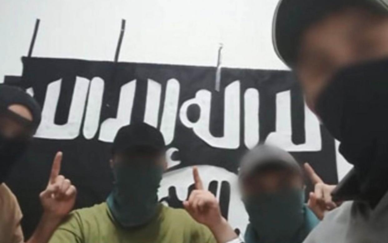 The four men wear black baseball caps and as they point to the sky in a gesture relating to belief in one god