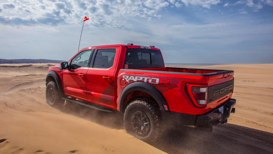 The 2023 Ford F-150 Raptor R driving on sand dunes.