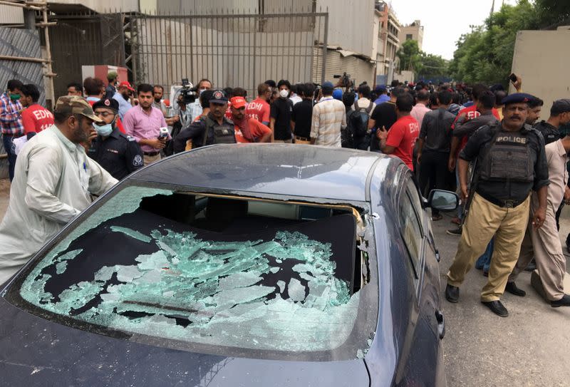Plainclothes police officer surveys site of attack at Pakistan Stocks Exchange entrance in Karachi
