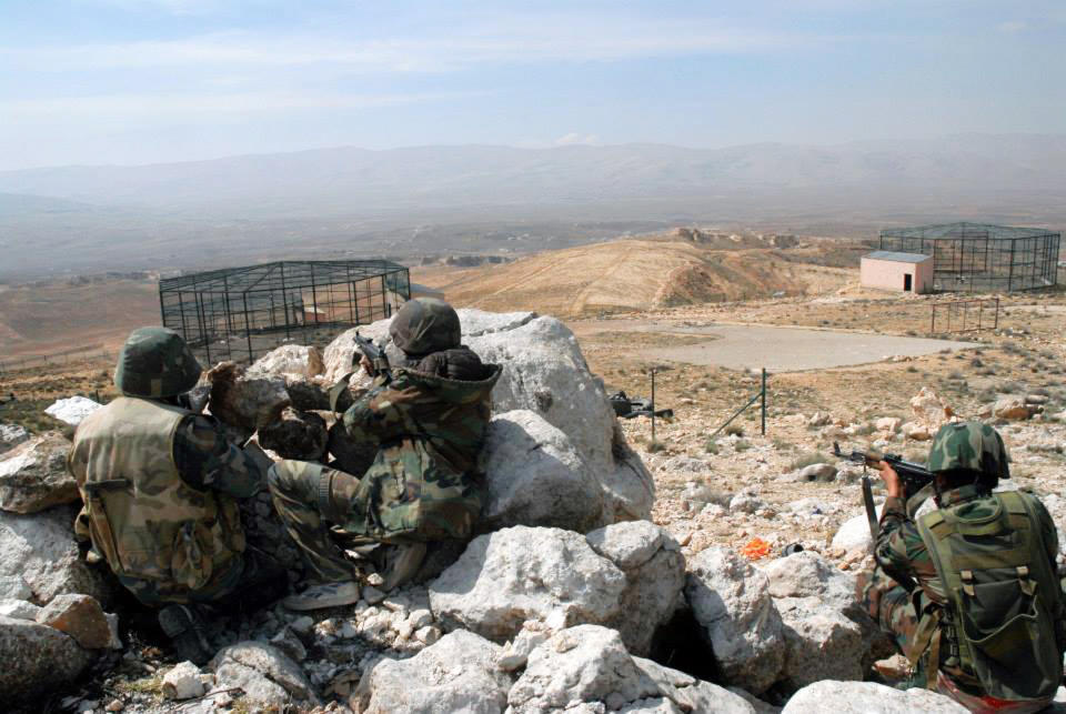 In this photo released on Sunday, April 13, 2014 by the Syrian official news agency SANA, Syrian government soldiers take their positions during clashes with Syrian rebels, near the town of Rankous, Syria. The seizure of the villages comes a day after Syrian troops backed by fighters from Lebanon's Shiite militant Hezbollah group captured the nearby town of Rankous. (AP Photo/SANA)