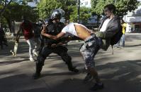 Demonstrators clash with a policeman before the World Cup final match between Argentina and Germany in Rio de Janeiro July 13, 2014. REUTERS/Nacho Doce (BRAZIL - Tags: SPORT SOCCER WORLD CUP POLITICS CIVIL UNREST)