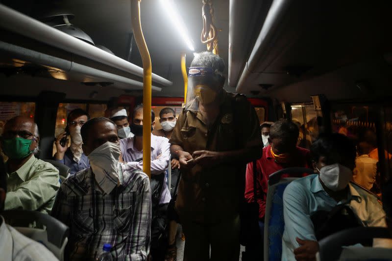 A conductor counts money on a bus amidst the spread of the coronavirus disease (COVID-19) in Mumbai