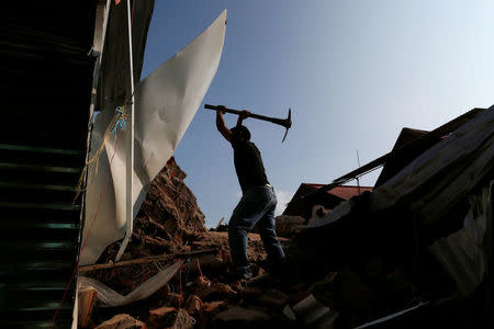 A man clears the debris of a building damaged in an earthquake that struck the southern coast of Mexico late on Thursday, in Juchitan, Mexico, September 9, 2017. REUTERS/Carlos Jasso