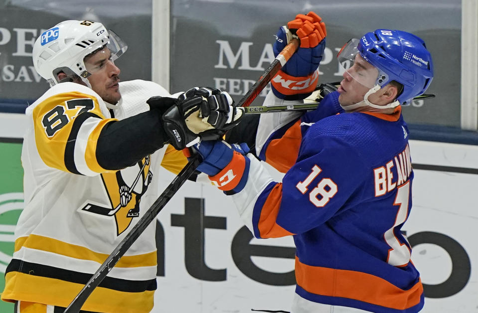 Pittsburgh Penguins center Sidney Crosby (87) uses his stick to fend off New York Islanders left wing Anthony Beauvillier (18) during the third period of an NHL hockey game, Sunday, Feb. 28, 2021, in Uniondale, N.Y. (AP Photo/Kathy Willens)