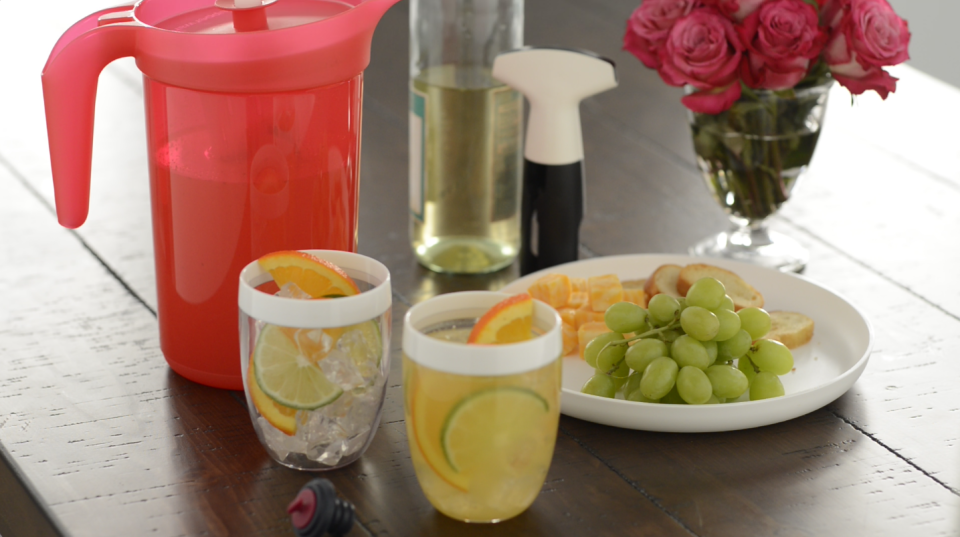 Pineapple sangria and a side of fruit being served on Tupperware goods.