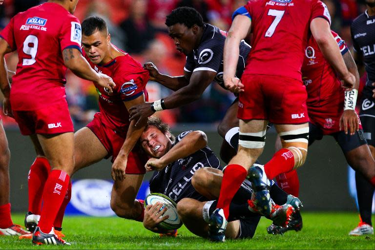 Sharks player Renaldo Bothma (centre) goes to ground during the Super 15 rugby match against Queensland Reds at the Suncorp Stadium in Brisbane on May 22, 2015