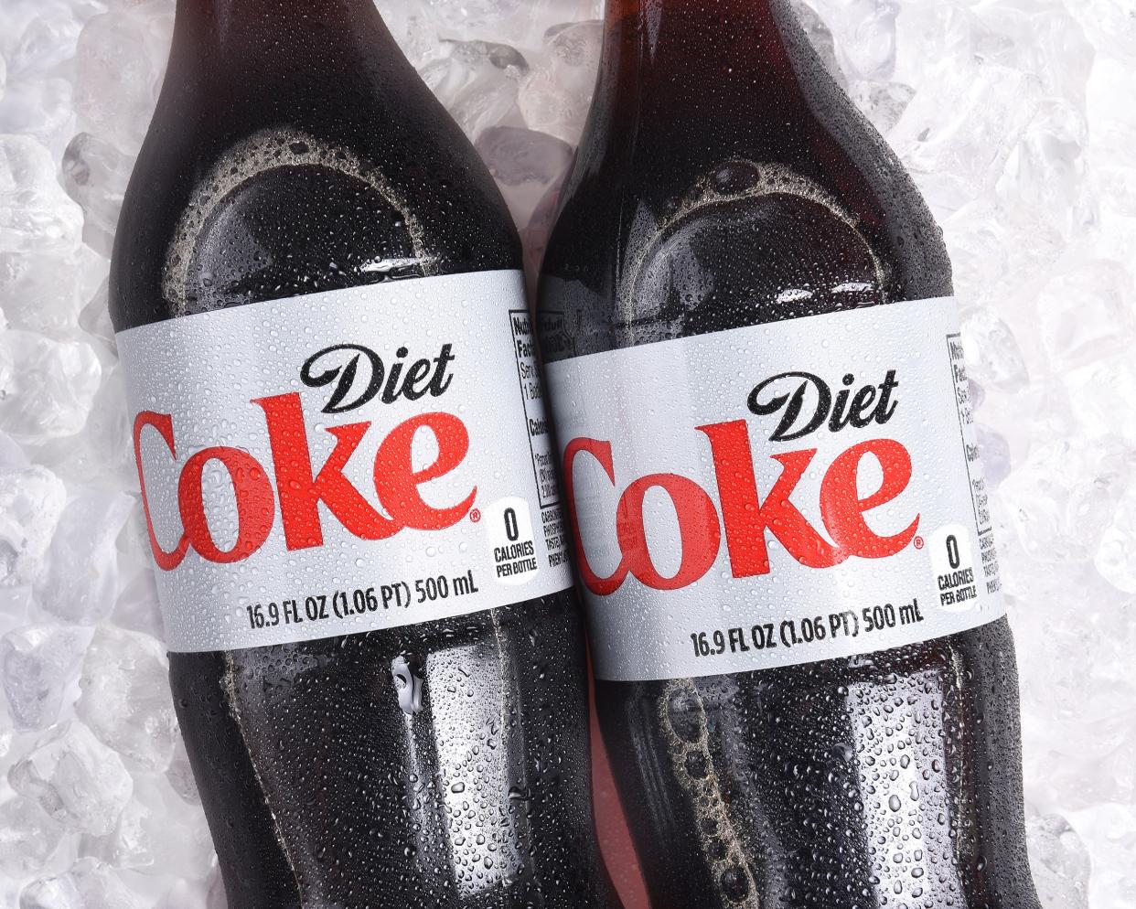 Two 16.9 fl. Oz. Plastic bottles of Diet Coke, mid-portion, on ice