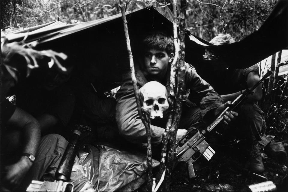 <p>A human skull keeps watch over US soldiers encamped in the Vietnamese jungle during the Vietnam War. (Photo: Terry Fincher/Daily Express/Hulton Archive/Getty Images) </p>