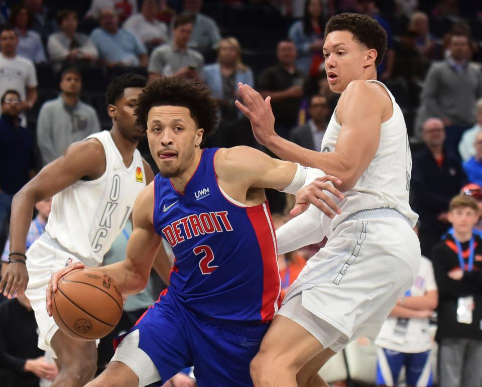 Detroit Pistons guard Cade Cunningham pushes past Oklahoma City Thunder center Isaiah Roby in the first half Friday, April 1, 2022, at the Paycom Center in Oklahoma City.
